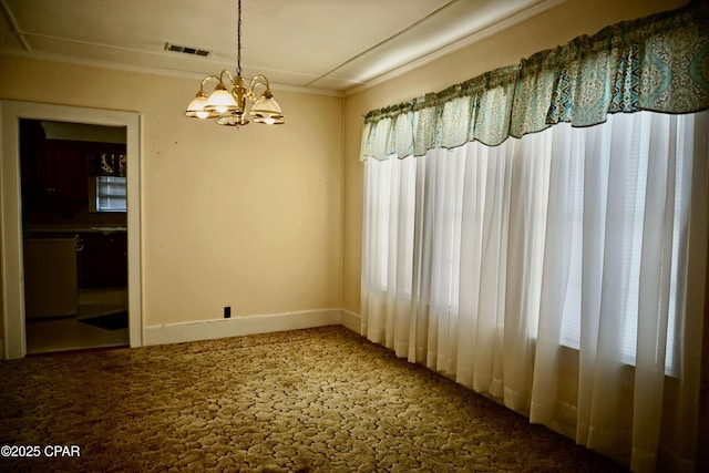 carpeted empty room featuring a chandelier