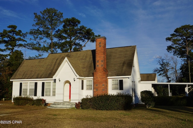 view of front of home with a front yard and a carport