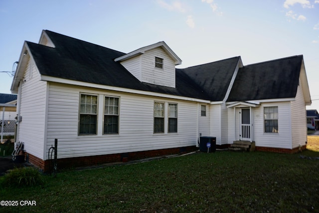 rear view of property featuring a yard and central air condition unit