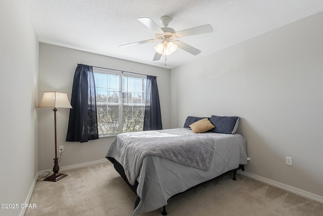 bedroom with light carpet, ceiling fan, and a textured ceiling