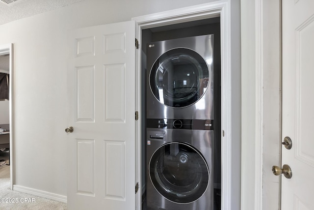 washroom with stacked washer and dryer and a textured ceiling