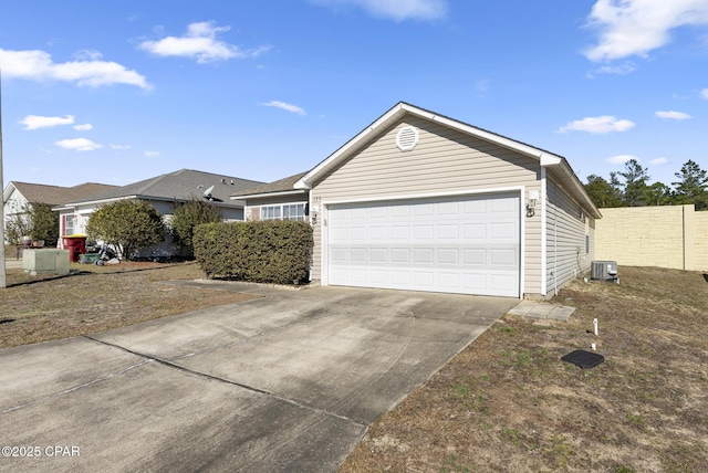 ranch-style house featuring a garage and cooling unit