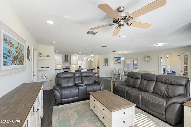 living room with ceiling fan, hardwood / wood-style floors, a textured ceiling, and french doors