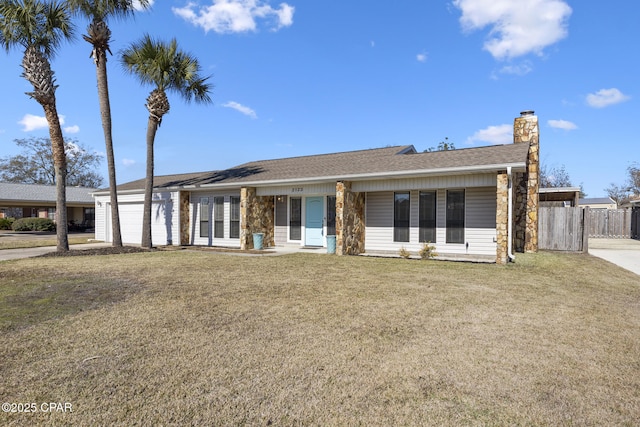 ranch-style home featuring a garage and a front lawn