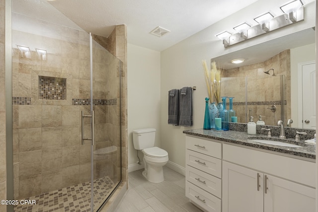 bathroom featuring toilet, vanity, and walk in shower