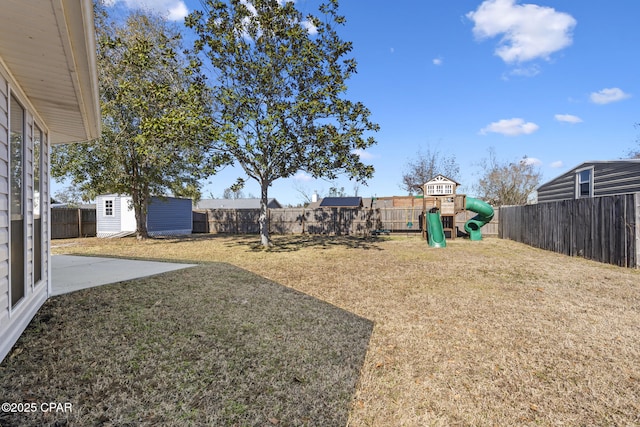 view of yard with a playground and a storage unit