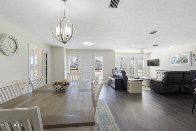 dining room with a textured ceiling, dark hardwood / wood-style flooring, and ceiling fan with notable chandelier