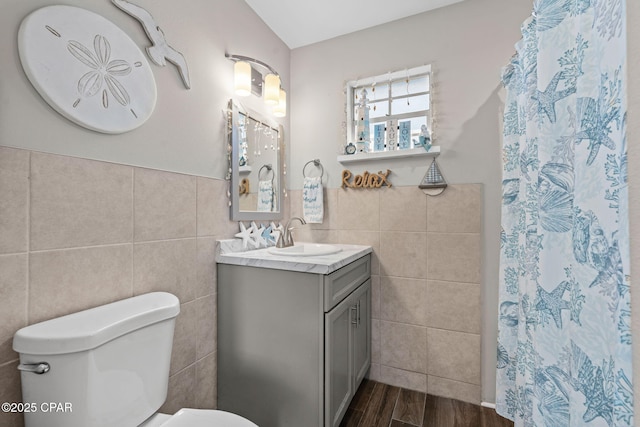 bathroom featuring tile walls, toilet, vanity, and a shower with shower curtain