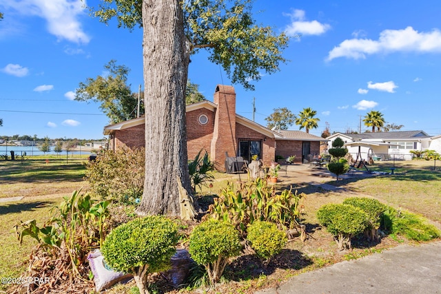 view of front of house featuring a front lawn and a water view