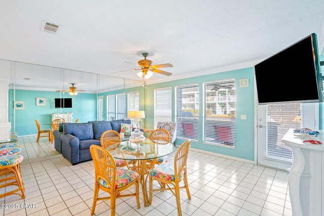 dining space with ceiling fan, light tile patterned floors, and crown molding