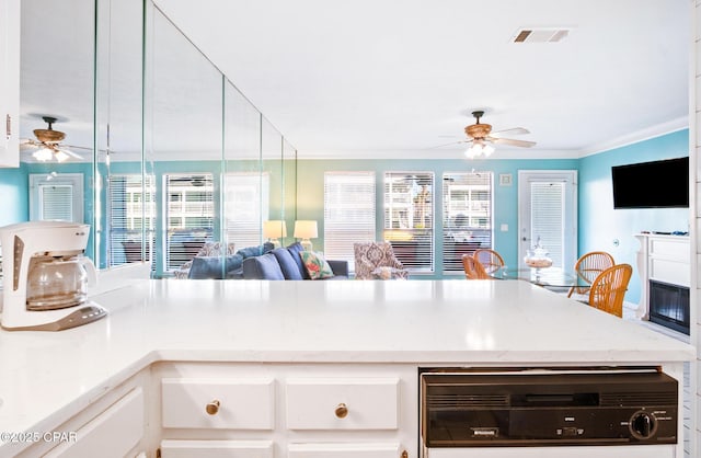 kitchen featuring light stone countertops, beverage cooler, white cabinetry, and ornamental molding