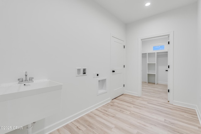 laundry area featuring sink, electric dryer hookup, light wood-type flooring, and washer hookup