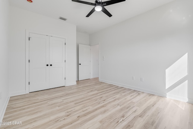 unfurnished bedroom featuring a closet, ceiling fan, and light hardwood / wood-style flooring