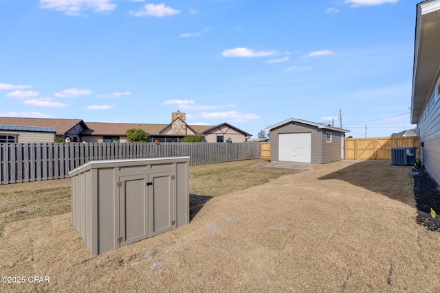 view of yard with a storage unit, central air condition unit, and a garage