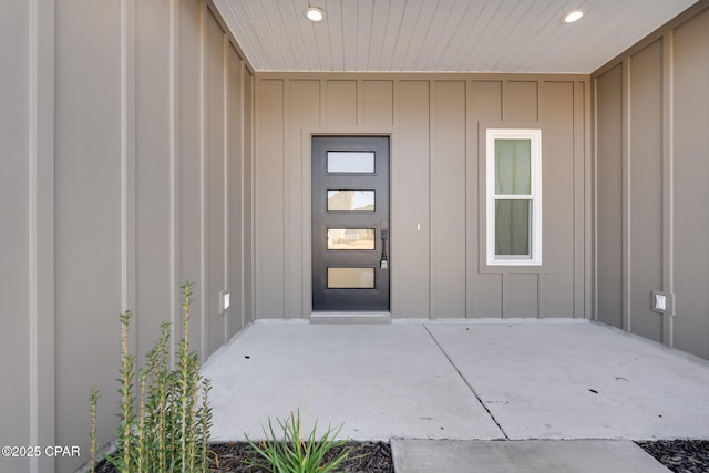 view of exterior entry with a patio