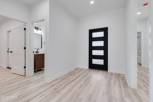 foyer featuring sink and light wood-type flooring