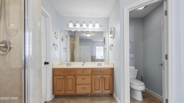 bathroom with a textured ceiling, toilet, vanity, and tile patterned flooring