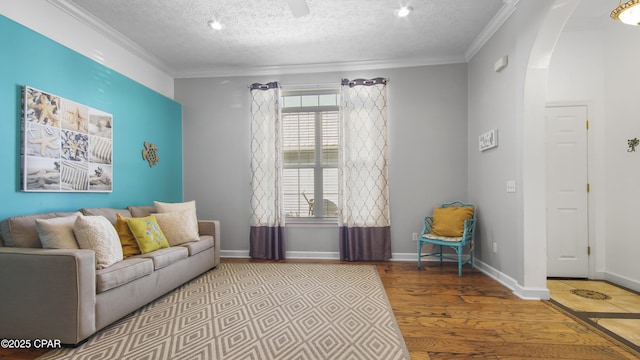 living room with light hardwood / wood-style floors, a textured ceiling, and ornamental molding