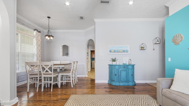 dining area featuring a wealth of natural light, crown molding, dark hardwood / wood-style flooring, and a textured ceiling