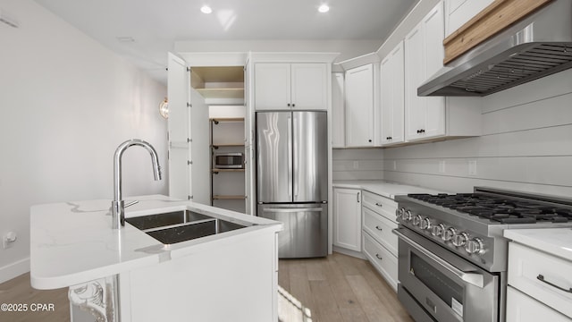 3511 Cottage Cove Ln, Panama City, FL 32408 - kitchen with stainless steel appliances, under cabinet range hood, light wood-style floors, white cabinetry, and a sink