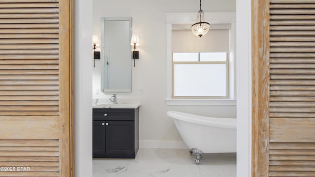 3511 Cottage Cove Ln, Panama City, FL 32408 - bathroom featuring marble look tiles, a freestanding tub, vanity, and baseboards