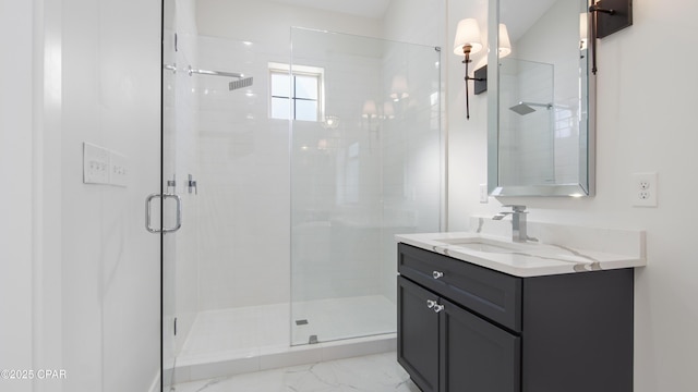 bathroom featuring a shower with shower door and vanity