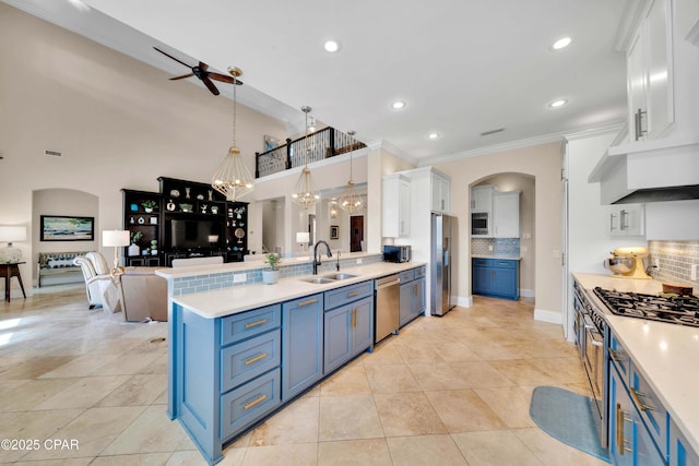 kitchen featuring blue cabinetry, light countertops, appliances with stainless steel finishes, white cabinets, and a sink