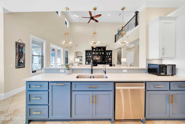 kitchen featuring stainless steel dishwasher, white cabinets, a sink, and light countertops