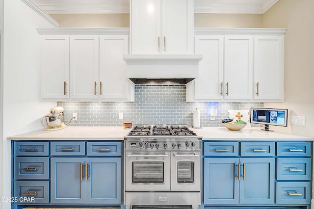 kitchen with light countertops, range with two ovens, backsplash, and white cabinets