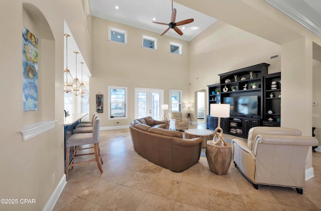 living room featuring crown molding, visible vents, a high ceiling, baseboards, and ceiling fan with notable chandelier