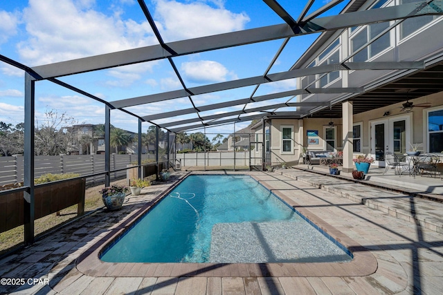 view of pool with a fenced in pool, french doors, a ceiling fan, a patio area, and a lanai