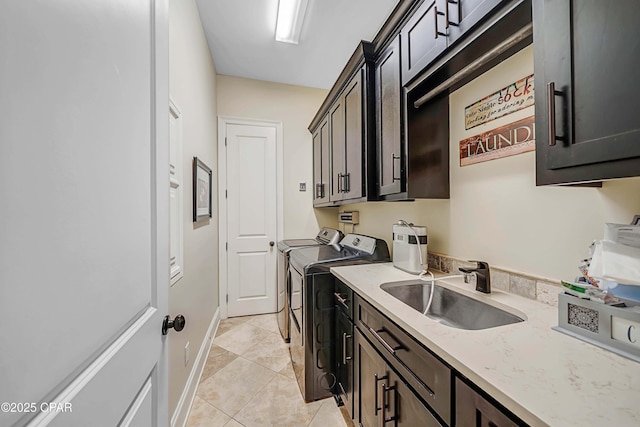 laundry area featuring cabinet space, a sink, washing machine and clothes dryer, and light tile patterned floors