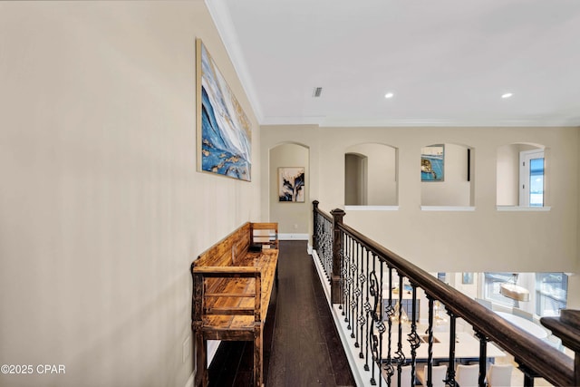 hallway featuring plenty of natural light, ornamental molding, dark wood-type flooring, and an upstairs landing