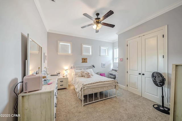 carpeted bedroom featuring a closet, a ceiling fan, and crown molding