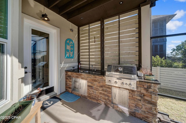 view of patio with fence, grilling area, a sink, and area for grilling