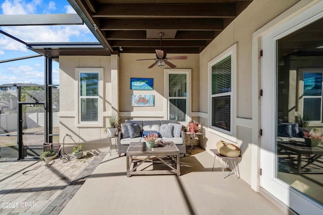 view of patio featuring a ceiling fan, a lanai, and an outdoor living space