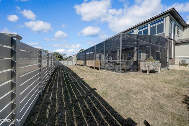 view of yard featuring glass enclosure, an AC wall unit, and a fenced backyard