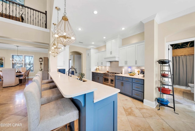 kitchen featuring a sink, double oven range, a kitchen breakfast bar, and a notable chandelier