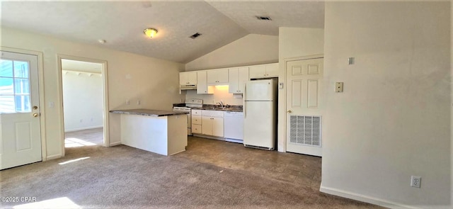 kitchen with white appliances, dark countertops, visible vents, and under cabinet range hood