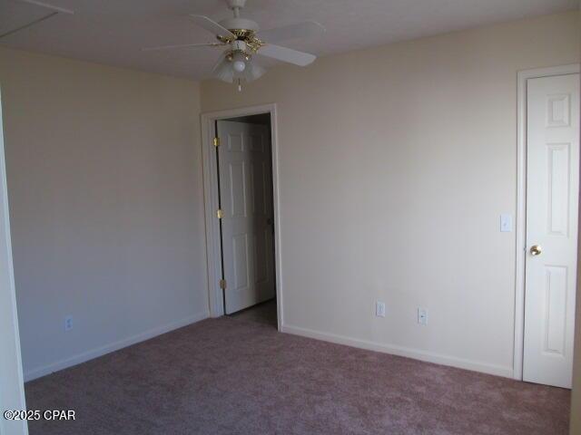 carpeted spare room featuring ceiling fan and baseboards