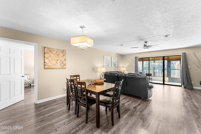 dining room featuring ceiling fan, a textured ceiling, and dark hardwood / wood-style flooring