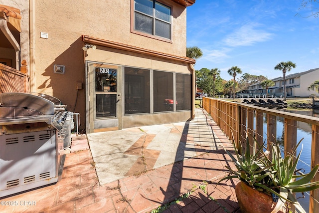 view of patio / terrace featuring a water view and a grill