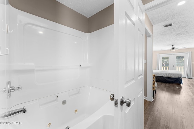 bathroom featuring a textured ceiling, ceiling fan, hardwood / wood-style floors, and french doors