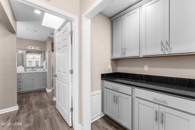 kitchen with dark hardwood / wood-style flooring, sink, gray cabinets, and a textured ceiling