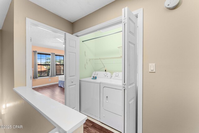 laundry area featuring dark hardwood / wood-style flooring and washing machine and clothes dryer