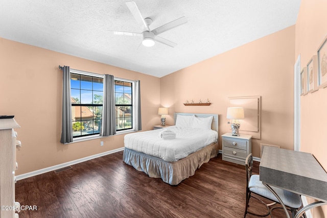 bedroom with ceiling fan, dark hardwood / wood-style flooring, and a textured ceiling