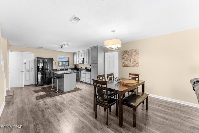 dining room featuring a textured ceiling and wood-type flooring