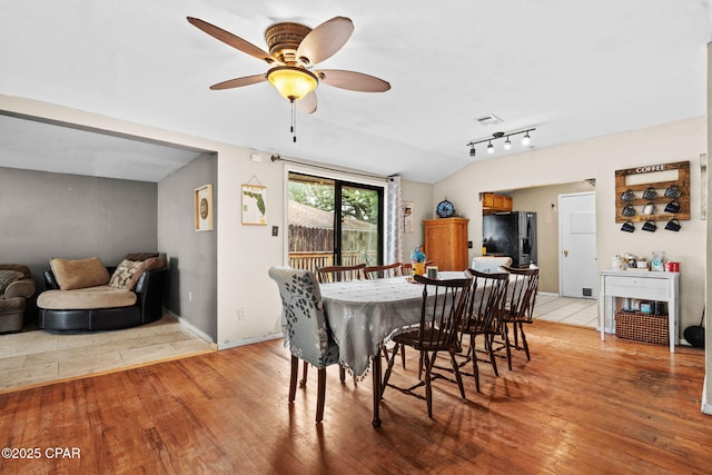 dining area featuring ceiling fan, lofted ceiling, and light hardwood / wood-style floors