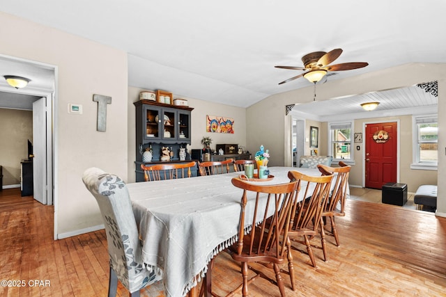 dining room featuring ceiling fan, light hardwood / wood-style floors, and lofted ceiling