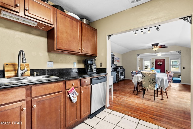 kitchen with light tile patterned floors, sink, vaulted ceiling, ceiling fan, and stainless steel dishwasher